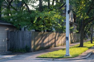 A Flock automated license plate reader affixed to a street pole in a residential neighborhood.