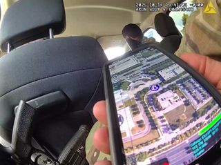 In the foreground is a cellphone showing a satellite view of a map with an indicator of their location.