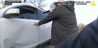 Chicago police officer Alexandra Giampapa, pulling on the driver's side door handle of Dexter Reed's car while pointing a gun at him moments before he was shot and killed by police.